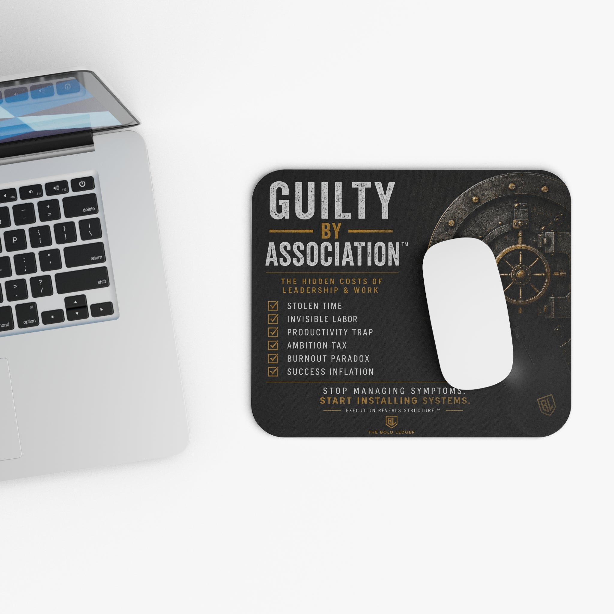 Mouse pad with text design next to a laptop on a white surface