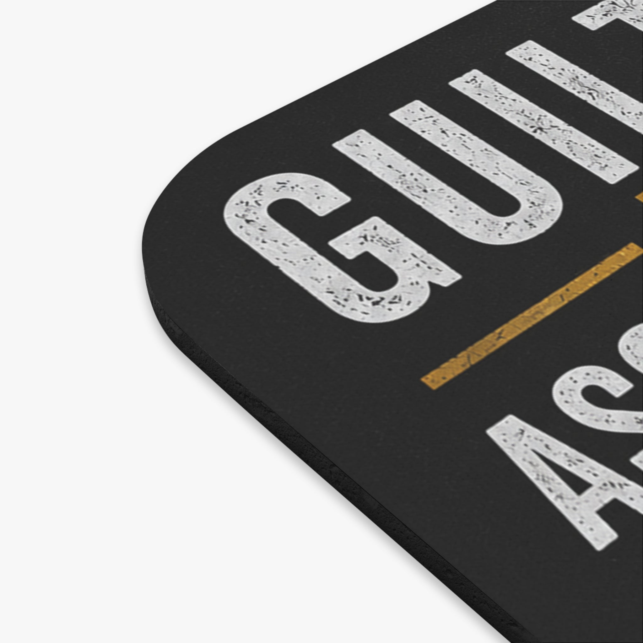 Close-up of a black coaster with white text on a white background